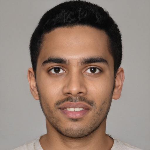 Joyful latino young-adult male with short  black hair and brown eyes