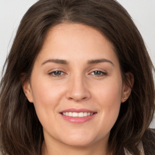 Joyful white young-adult female with long  brown hair and brown eyes