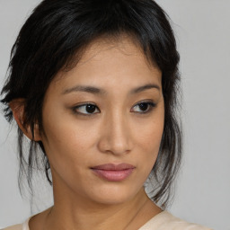 Joyful asian young-adult female with medium  brown hair and brown eyes