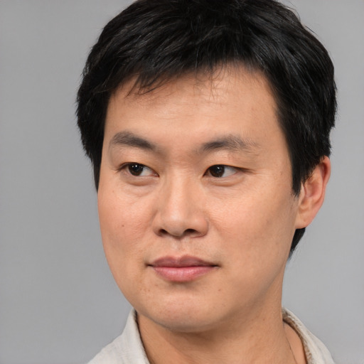 Joyful asian young-adult male with short  black hair and brown eyes