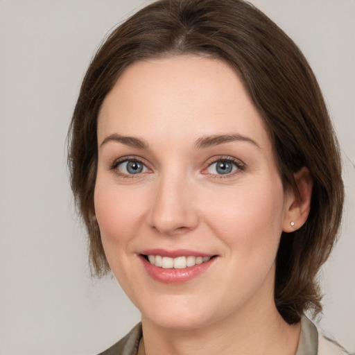 Joyful white young-adult female with medium  brown hair and grey eyes