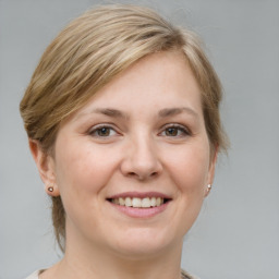 Joyful white young-adult female with medium  brown hair and grey eyes