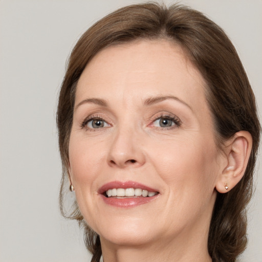 Joyful white adult female with medium  brown hair and grey eyes