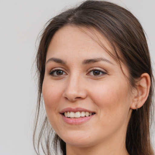 Joyful white young-adult female with long  brown hair and brown eyes