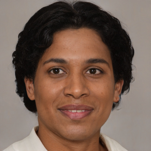 Joyful latino adult female with short  brown hair and brown eyes