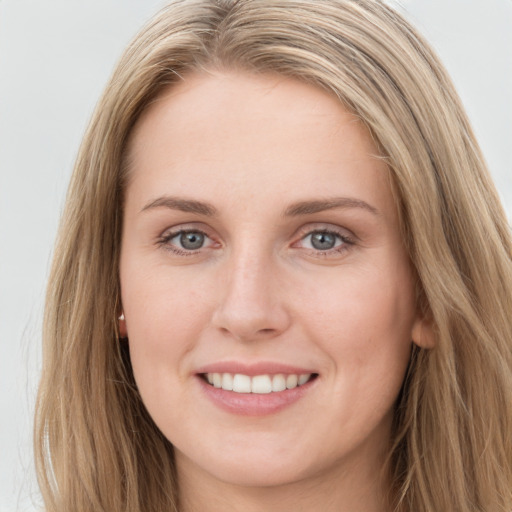 Joyful white young-adult female with long  brown hair and blue eyes