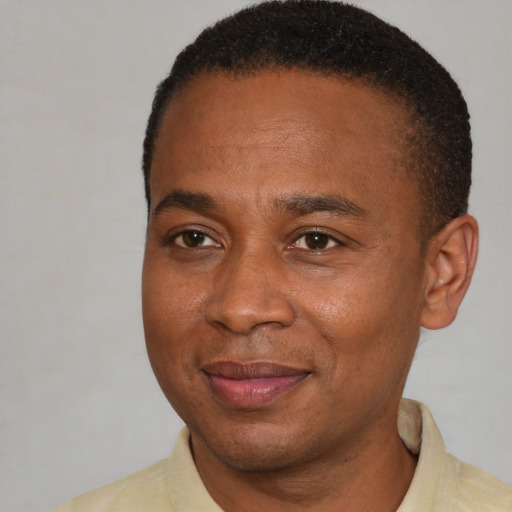 Joyful black adult male with short  brown hair and brown eyes