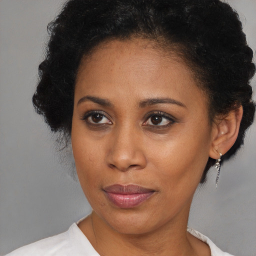 Joyful black adult female with short  brown hair and brown eyes