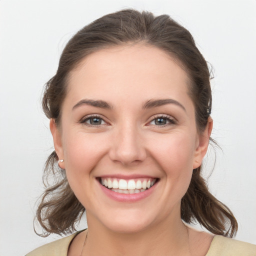 Joyful white young-adult female with medium  brown hair and grey eyes