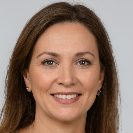 Joyful white adult female with long  brown hair and grey eyes