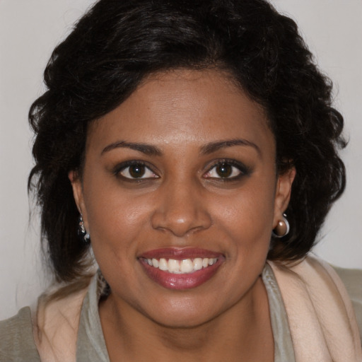 Joyful black young-adult female with long  brown hair and brown eyes