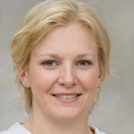 Joyful white young-adult female with medium  blond hair and blue eyes