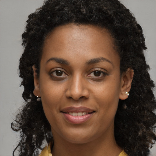 Joyful black young-adult female with long  brown hair and brown eyes