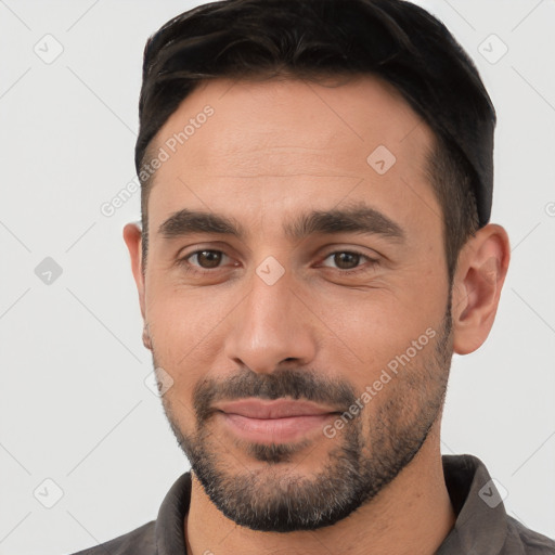 Joyful white young-adult male with short  black hair and brown eyes