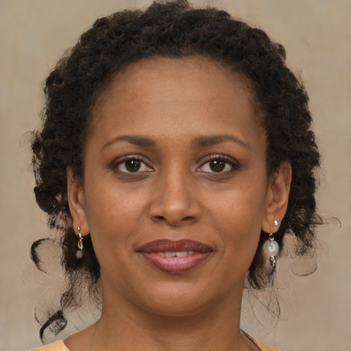 Joyful black young-adult female with medium  brown hair and brown eyes
