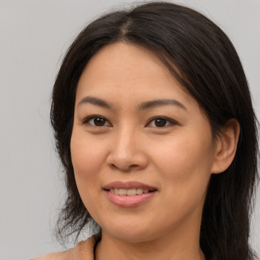 Joyful asian young-adult female with long  brown hair and brown eyes