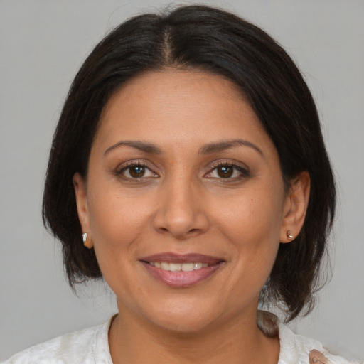 Joyful black adult female with medium  brown hair and brown eyes