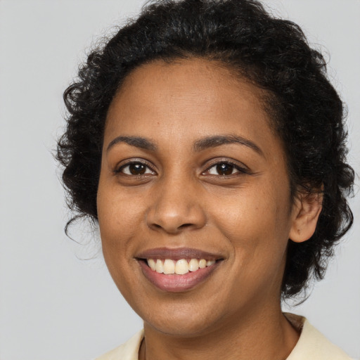 Joyful black young-adult female with long  brown hair and brown eyes
