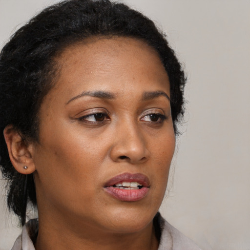 Joyful black young-adult female with medium  brown hair and brown eyes