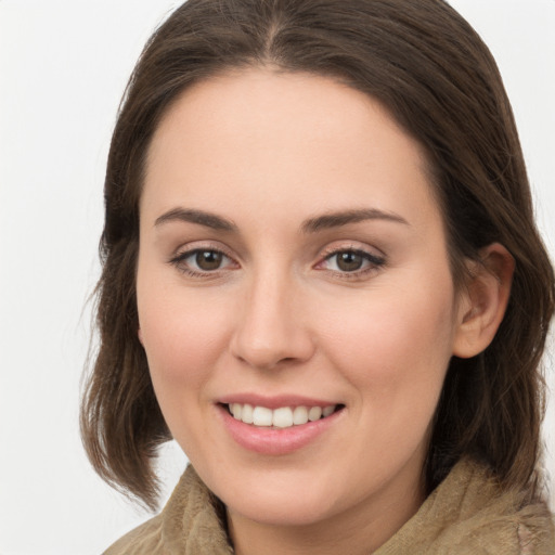 Joyful white young-adult female with medium  brown hair and grey eyes