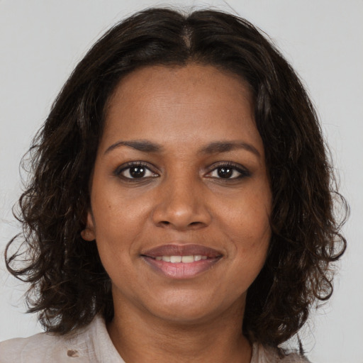 Joyful black young-adult female with medium  brown hair and brown eyes