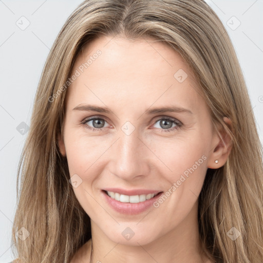 Joyful white young-adult female with long  brown hair and grey eyes