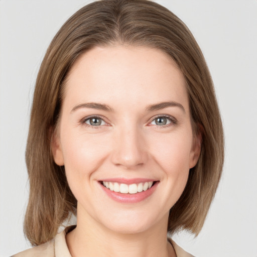 Joyful white young-adult female with medium  brown hair and grey eyes