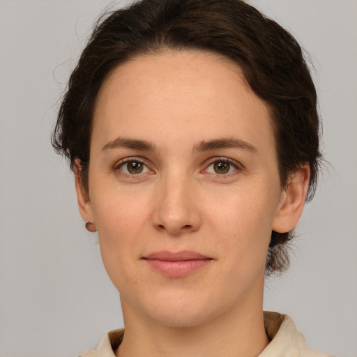 Joyful white young-adult female with short  brown hair and green eyes