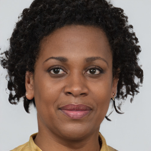 Joyful black adult female with short  brown hair and brown eyes