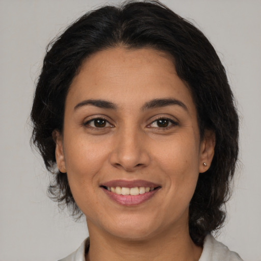 Joyful latino young-adult female with medium  brown hair and brown eyes