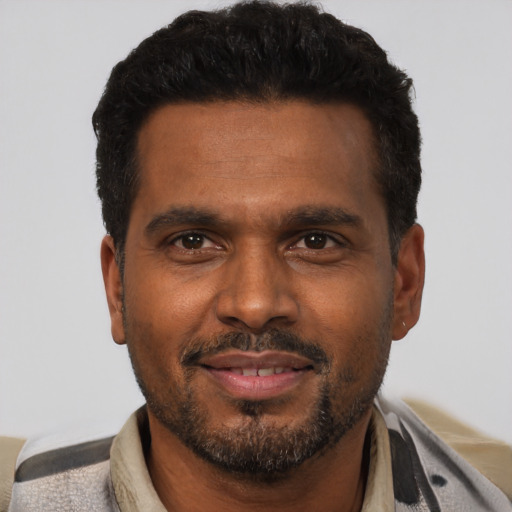 Joyful black adult male with short  black hair and brown eyes