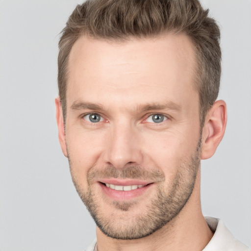 Joyful white adult male with short  brown hair and grey eyes