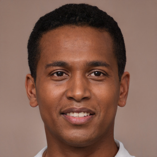 Joyful black young-adult male with short  brown hair and brown eyes