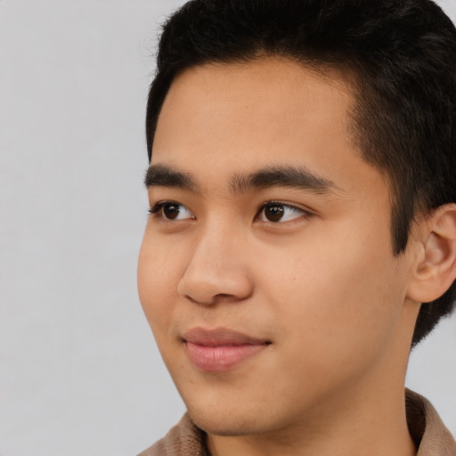 Joyful latino young-adult male with short  brown hair and brown eyes