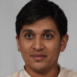 Joyful latino young-adult male with short  black hair and brown eyes