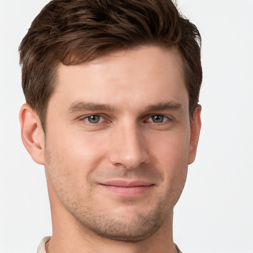 Joyful white young-adult male with short  brown hair and grey eyes