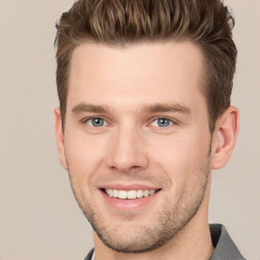 Joyful white young-adult male with short  brown hair and grey eyes