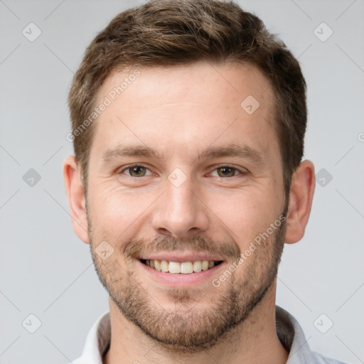 Joyful white young-adult male with short  brown hair and grey eyes