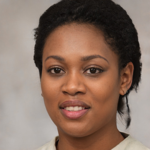 Joyful black young-adult female with short  black hair and brown eyes