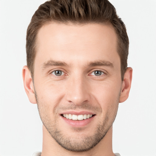 Joyful white young-adult male with short  brown hair and grey eyes