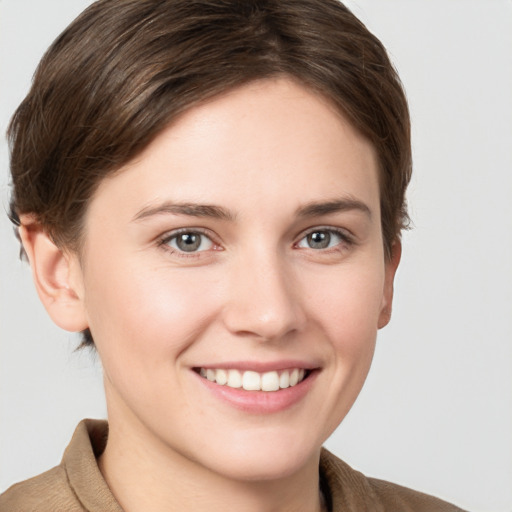 Joyful white young-adult female with short  brown hair and grey eyes