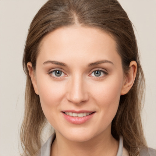 Joyful white young-adult female with medium  brown hair and grey eyes