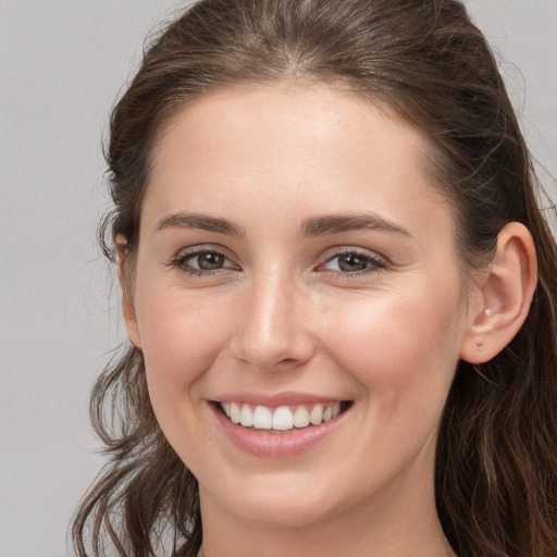 Joyful white young-adult female with long  brown hair and grey eyes