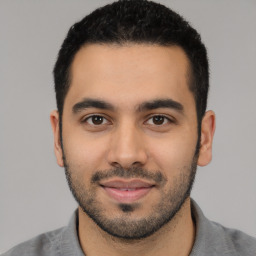 Joyful latino young-adult male with short  black hair and brown eyes