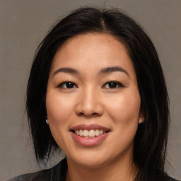 Joyful asian young-adult female with medium  brown hair and brown eyes