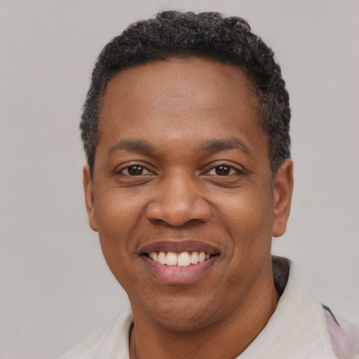 Joyful black adult male with short  black hair and brown eyes