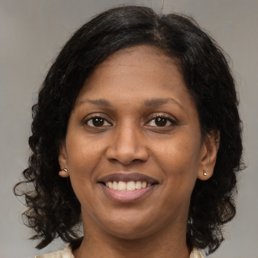 Joyful black adult female with medium  brown hair and brown eyes