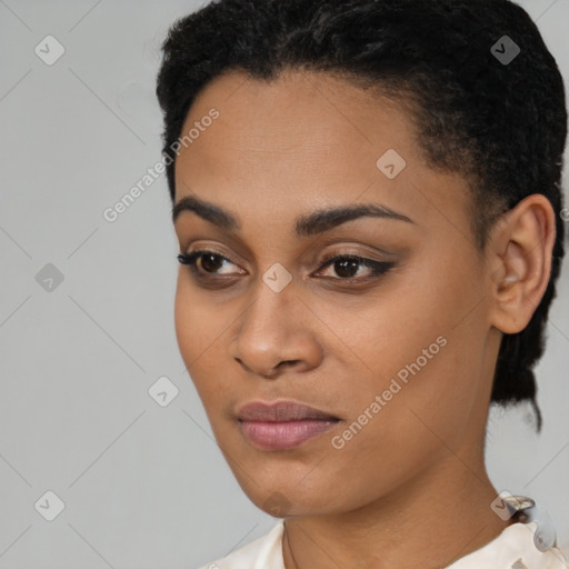 Joyful black young-adult female with short  black hair and brown eyes