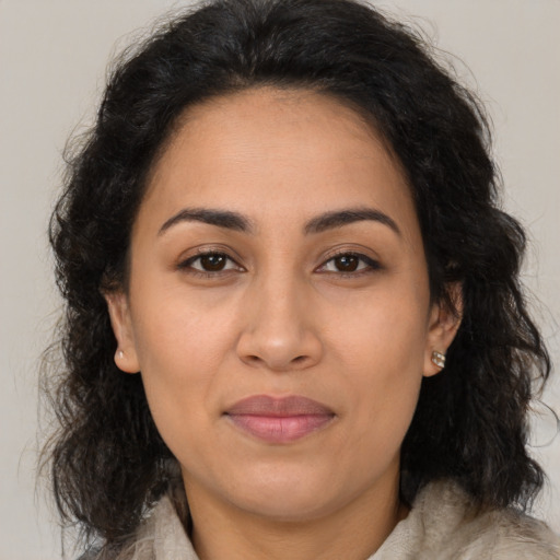 Joyful latino adult female with long  brown hair and brown eyes