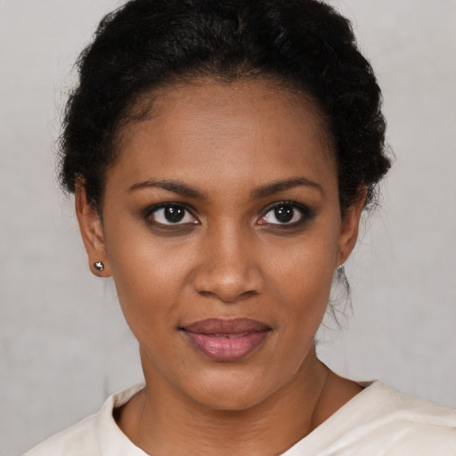 Joyful black young-adult female with short  brown hair and brown eyes
